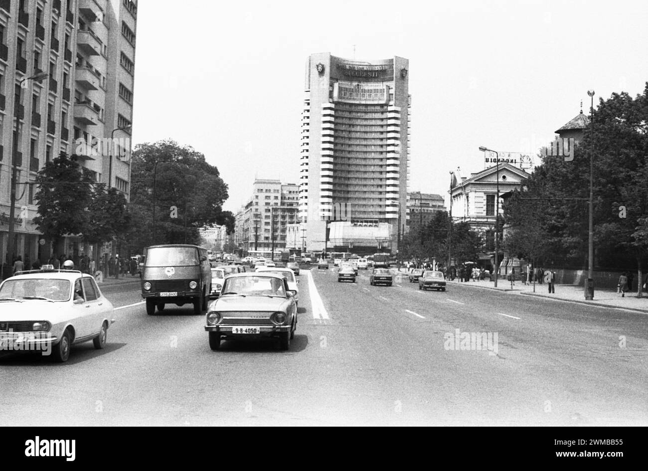 Bucarest, Roumanie, approx. 1980. Véhicules circulant sur le boulevard I.C. Bratianu à travers la place de l'Université, avec l'hôtel Intercontinental vu à l'arrière. Banque D'Images