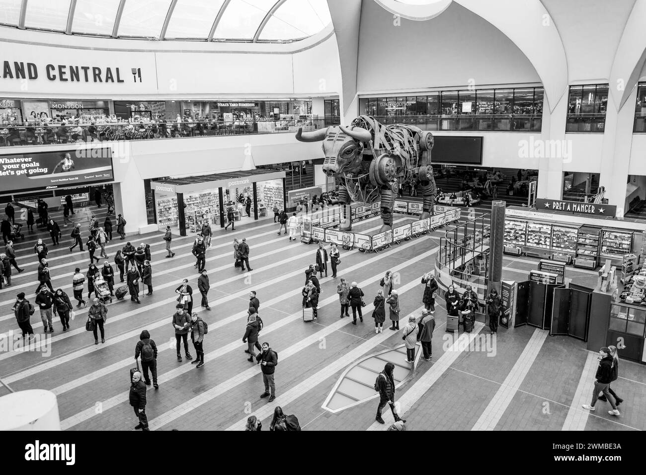 Clients et passagers à la gare de Birmingham New Street, marchant et debout dans le hall principal avec Ozzy le taureau enragé. Banque D'Images