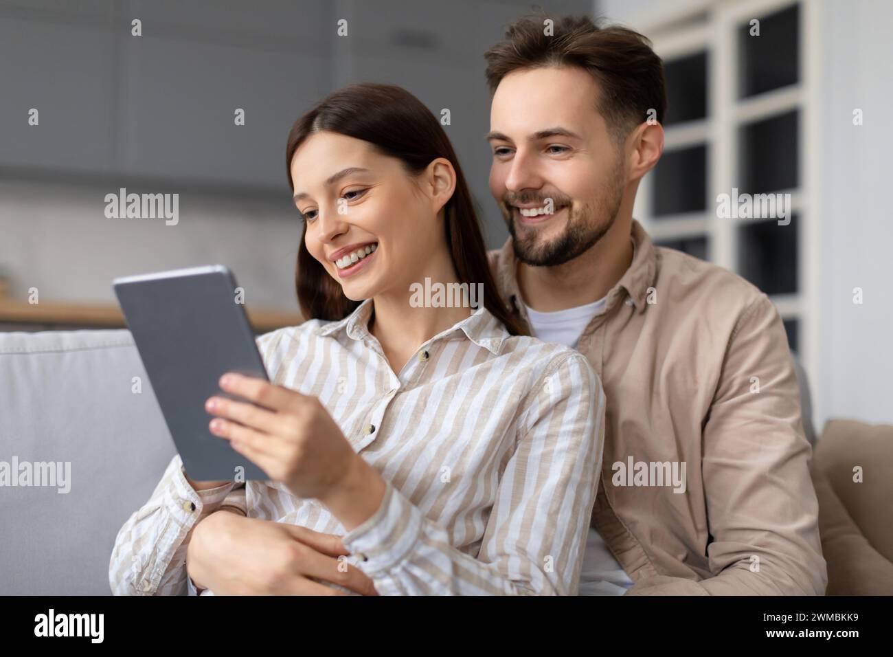 Heureux conjoints européens partageant un moment avec tablette numérique Banque D'Images