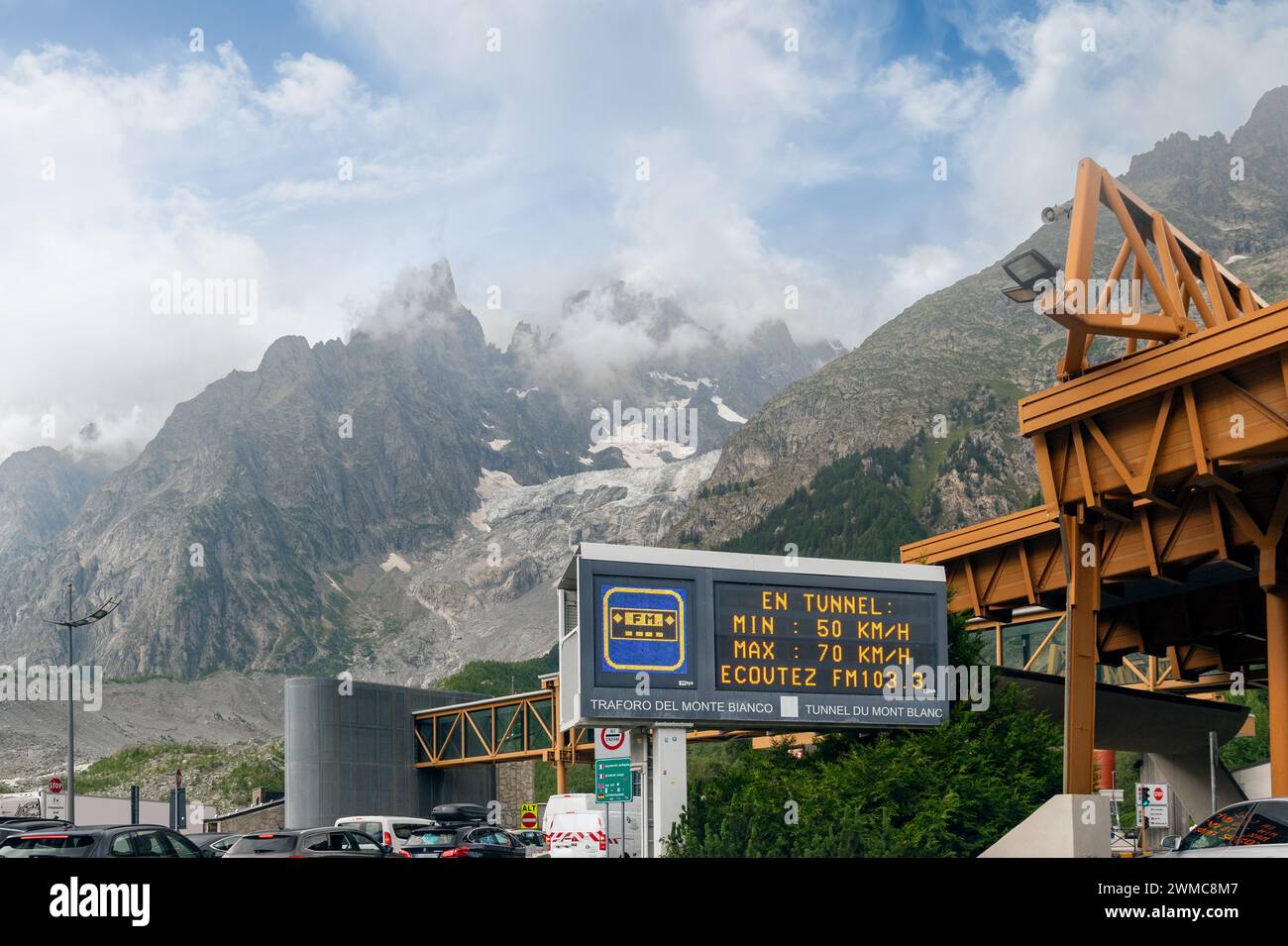 Signalisation électronique signalant les limites de vitesse autorisées dans le tunnel du Mont Blanc, avec le massif du Mont Blanc en arrière-plan, Courmayeur, Vallée d'Aoste Banque D'Images