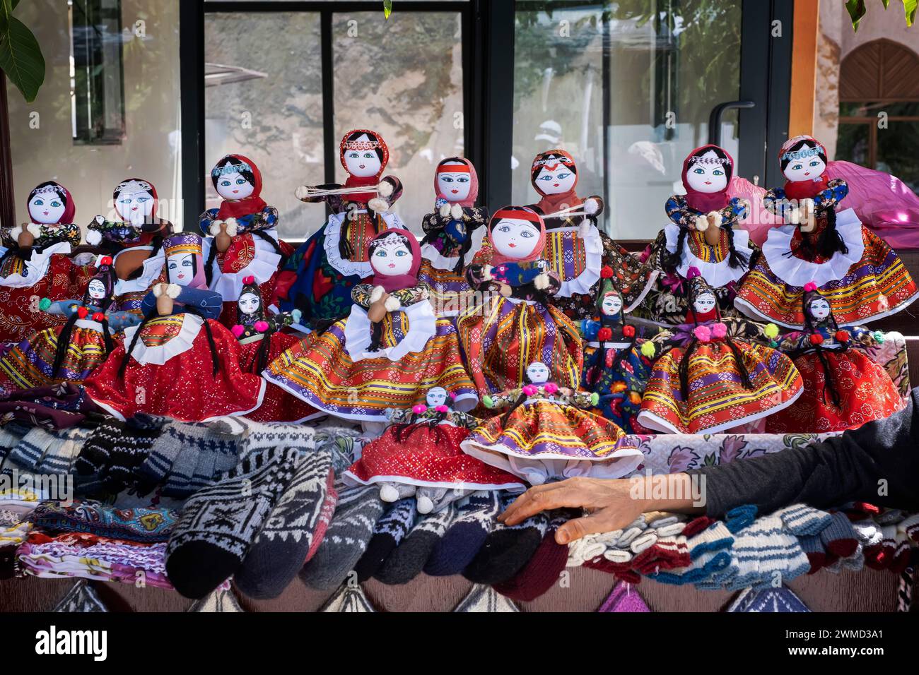 Stalle de rue de poupées de chiffon vêtues de costumes typiques, la main de l'artisan appuyée sur la stalle, dans le village de poupées de Soganli en Cappadoce Banque D'Images