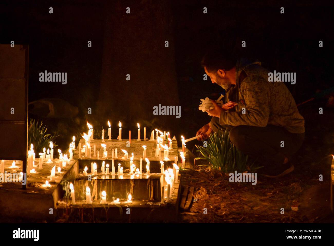 Srinagar, Inde. 25 février 2024. Un musulman chiite du Cachemire allume des bougies sur la tombe d'un parent pour marquer Lailat al-Barat (nuit du salut), l'une des cinq nuits saintes des musulmans comme la nuit de la fortune et du pardon à Srinagar. Les musulmans visitent les cimetières pour le salut des âmes défuntes et considèrent Lailat al-Barat comme la nuit du pardon. (Photo de Saqib Majeed/SOPA images/Sipa USA) crédit : Sipa USA/Alamy Live News Banque D'Images