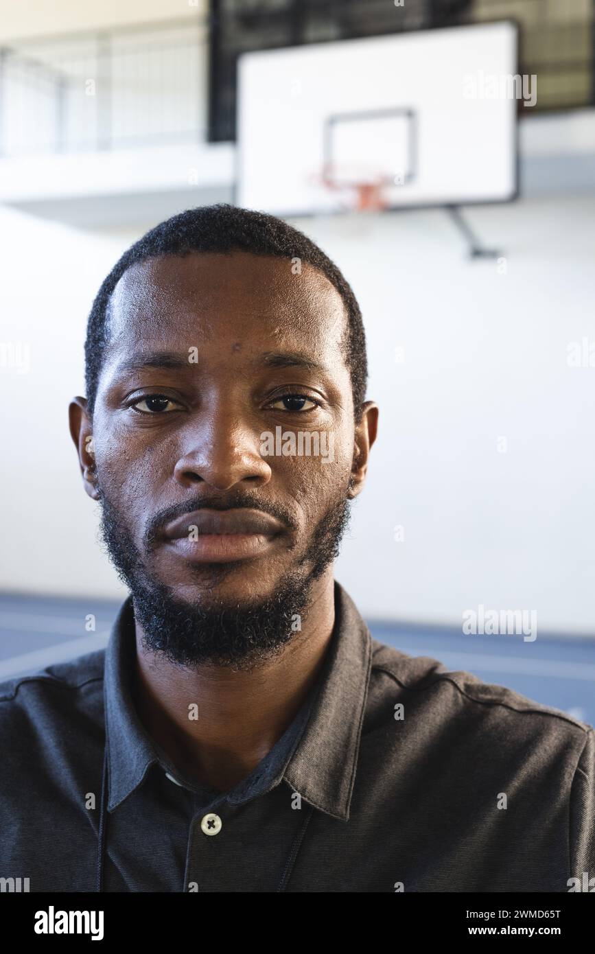 Homme afro-américain se tient dans un gymnase d'école Banque D'Images