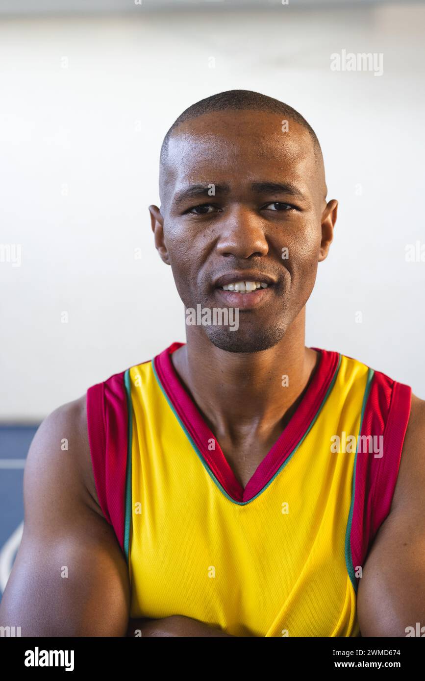 Homme afro-américain dans un maillot de basket-ball pose avec confiance Banque D'Images