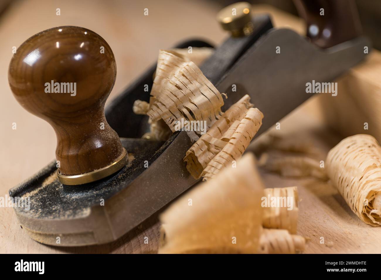 Photo horizontale gros plan d'un avion antique à la main sur une surface en bois, entouré de copeaux de bois délicats, mettant en valeur l'artisanat fin. Busines Banque D'Images