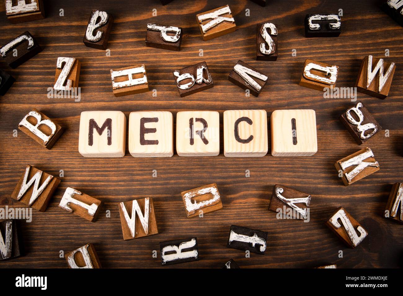 Merci en français. Blocs d'alphabet sur fond de texture de bois. Banque D'Images