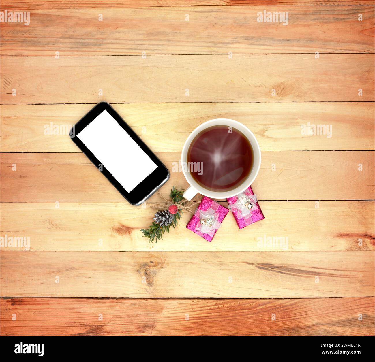 Smartphone, cadeaux. et une tasse de boisson chaude sur un fond en bois. Vue de dessus. Noël. Surprise matinale. Concept. Amour. Attention. Attention. Confort à la maison. Banque D'Images