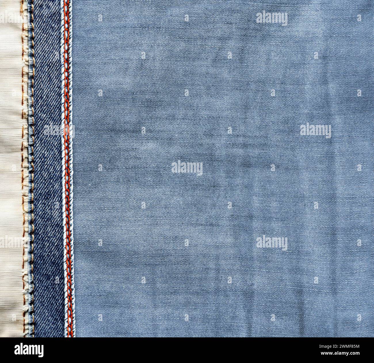 Fond denim bleu et gris clair avec une couture rouge. Texture de tissu Jean denim de couleur bleu clair avec bordure décorative. Copier l'espace pour le texte Banque D'Images