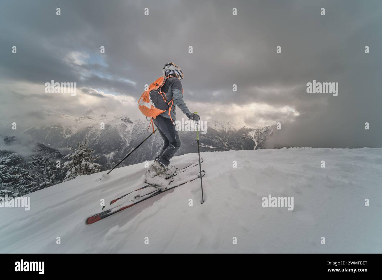 Petit garçon avec des skis d'alpinisme en montée sur les alpes italiennes Banque D'Images