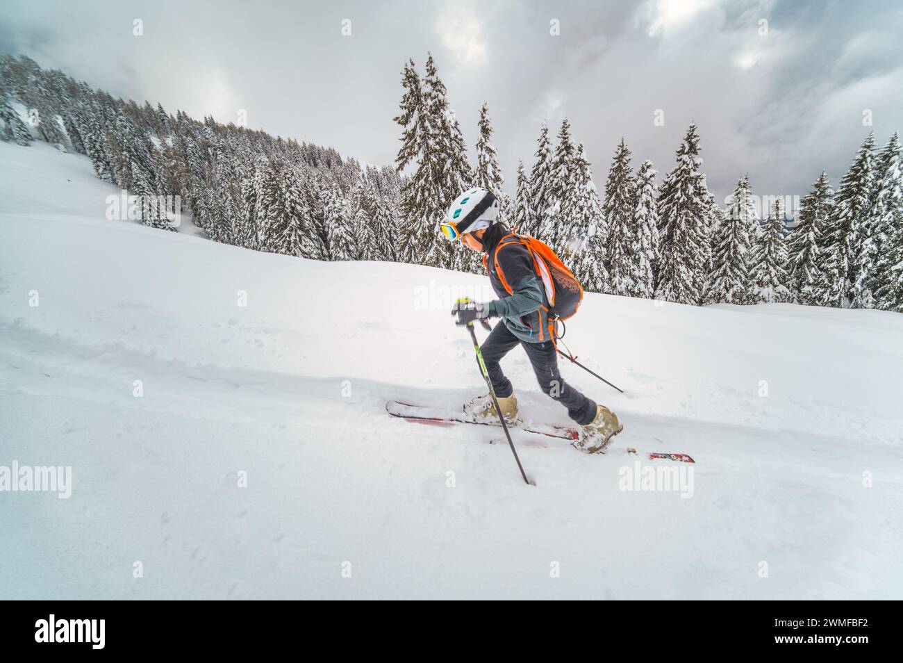 Petit garçon pratiquant le ski alpinisme en montée Banque D'Images