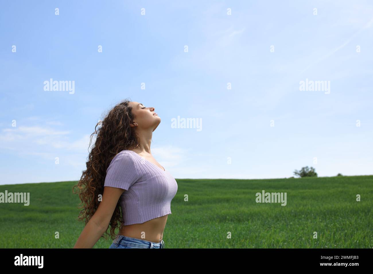 Profil d'une femme occasionnelle respirant l'air frais dans un large champ Banque D'Images