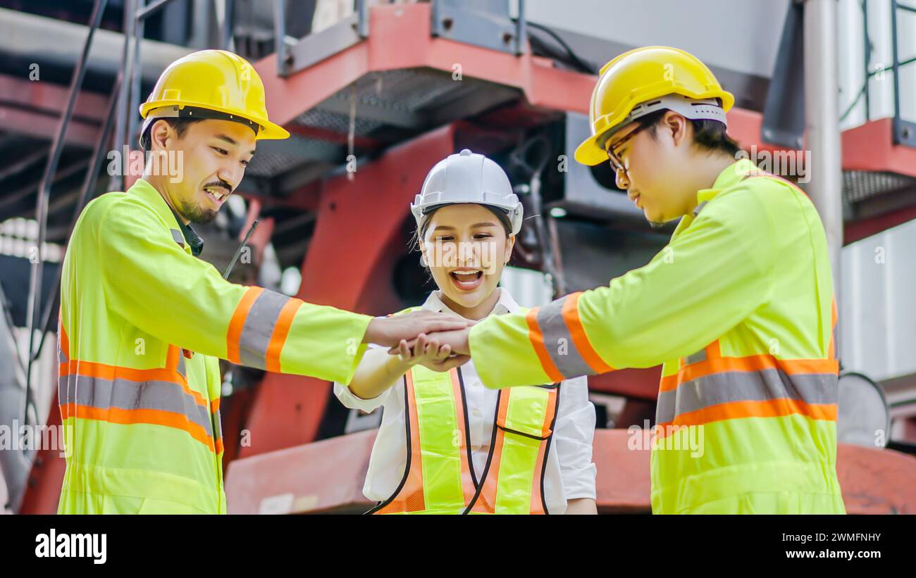 Les dockers se tiennent les mains ensemble dans le terminal à conteneurs. Logistique, travail d'équipe Banque D'Images