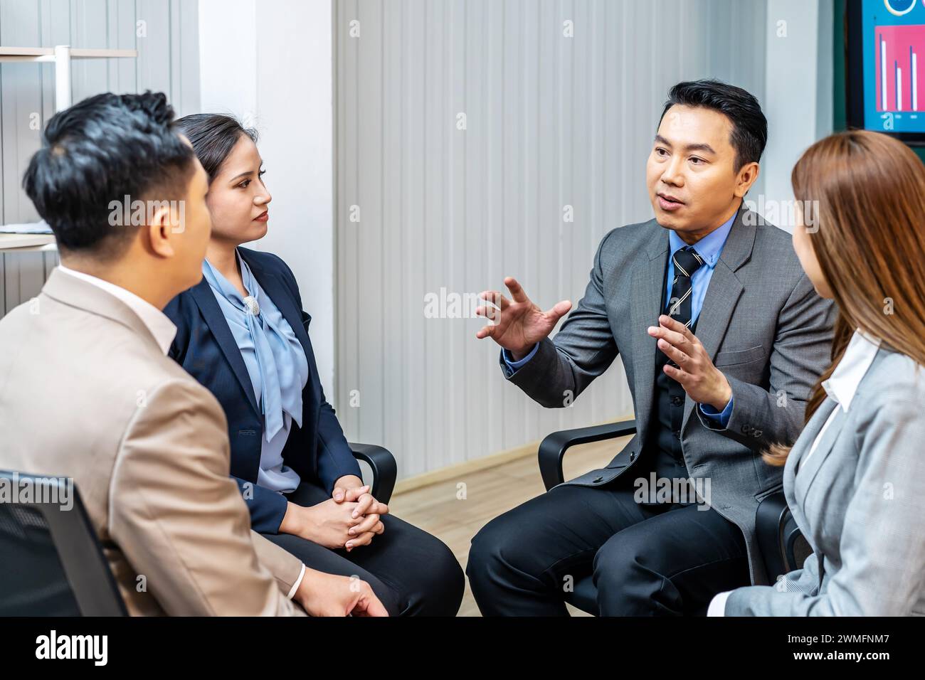 Un leader dans un bureau d'affaires en discussion avec les membres de l'équipe Banque D'Images