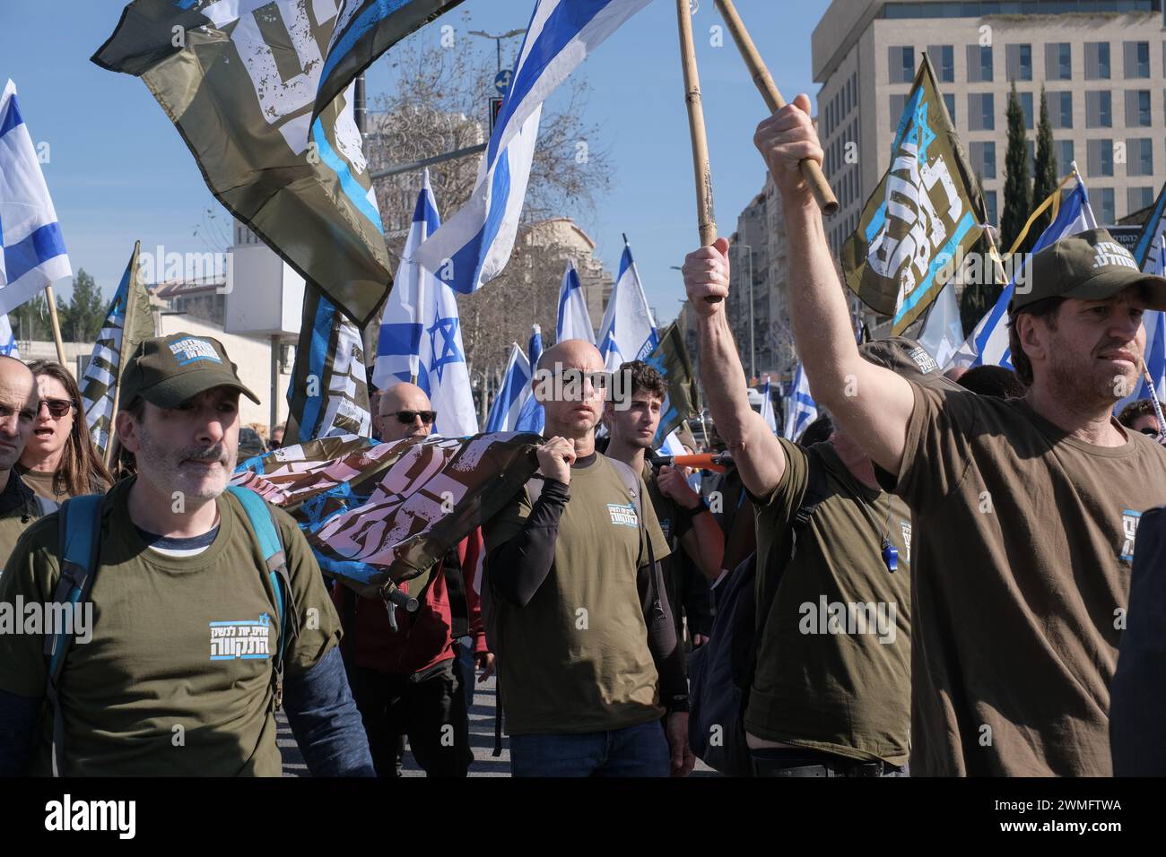 Jérusalem, Israël. 26 février 2024. Les manifestants se rassemblent devant la Cour suprême d'Israël alors que les juges entendent des appels contestant les réformes proposées par Netanyahou en matière de service militaire. Le projet de loi vise à étendre le service obligatoire pour les hommes et les réservistes, tandis que les manifestants exigent un partage égal du fardeau et la fin des exemptions pour les communautés ultra orthodoxes, appelant à ce que tout le monde passe sous le brancard. Crédit : NIR Alon/Alamy Live News Banque D'Images