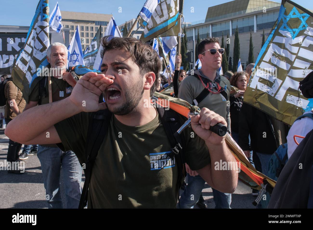 Jérusalem, Israël. 26 février 2024. Les manifestants se rassemblent devant la Cour suprême d'Israël alors que les juges entendent des appels contestant les réformes proposées par Netanyahou en matière de service militaire. Le projet de loi vise à étendre le service obligatoire pour les hommes et les réservistes, tandis que les manifestants exigent un partage égal du fardeau et la fin des exemptions pour les communautés ultra orthodoxes, appelant à ce que tout le monde passe sous le brancard. Crédit : NIR Alon/Alamy Live News Banque D'Images