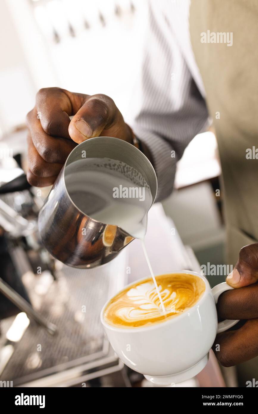 Un barista afro-américain fabrique un latte dans un café Banque D'Images
