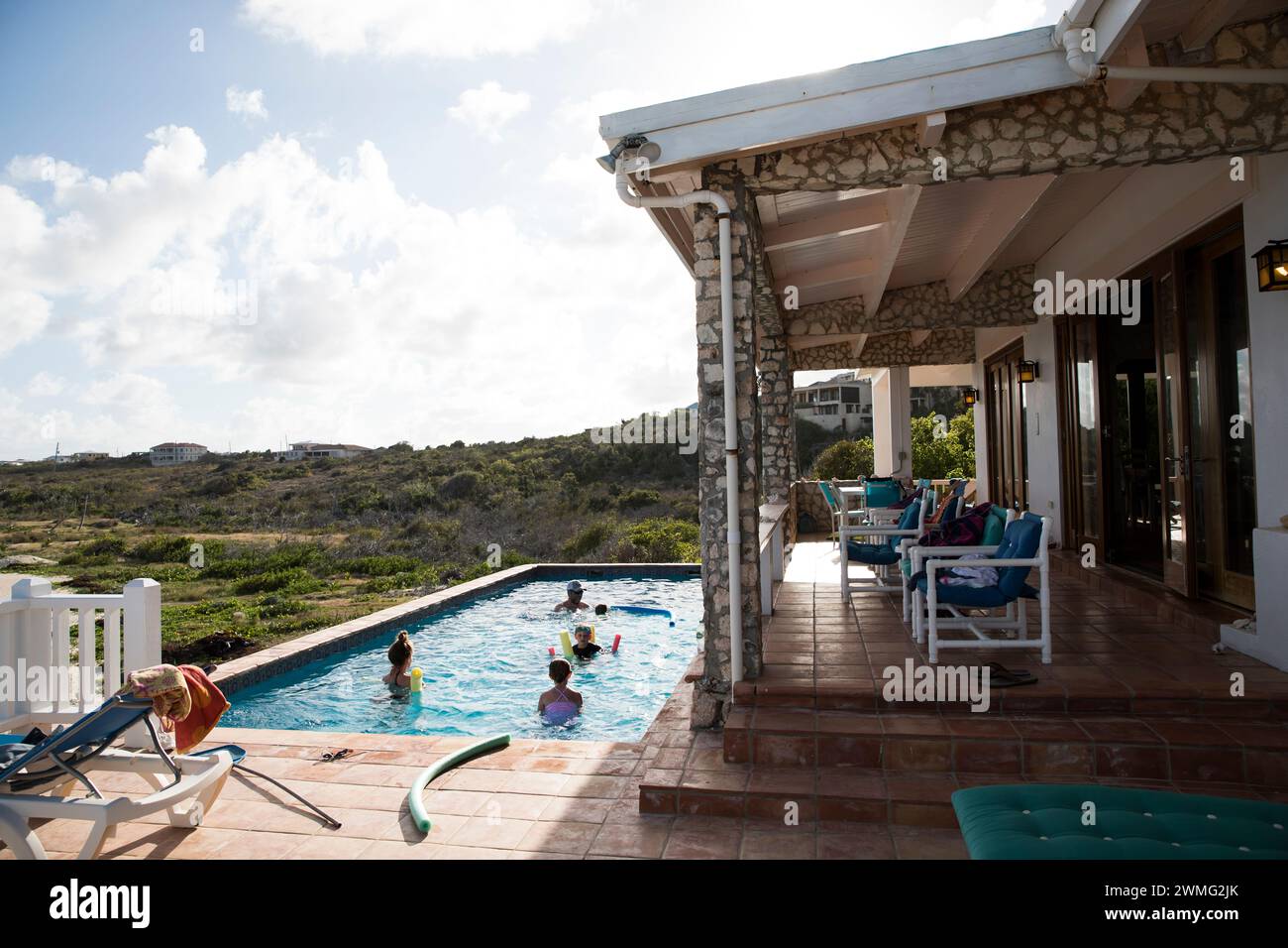 Famille heureuse dans la piscine à Caribbean Villa, en vacances Banque D'Images