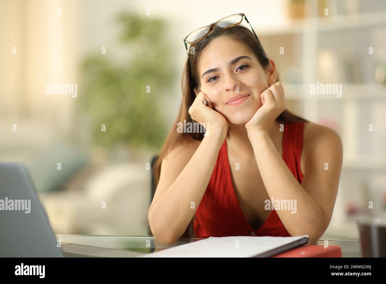 Portrait de face d'un étudiant heureux regardant la caméra à la maison Banque D'Images