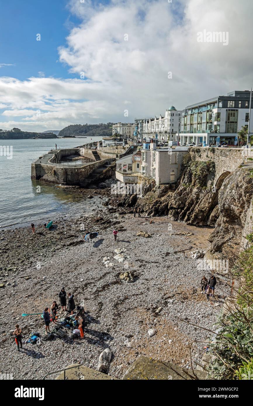Les paddle-boarders profitent du soleil de fin février sur une plage de galets à West Hoe à Plymouth. La plage récemment mis à l'abri d'une falaise dangereuse est libre un Banque D'Images