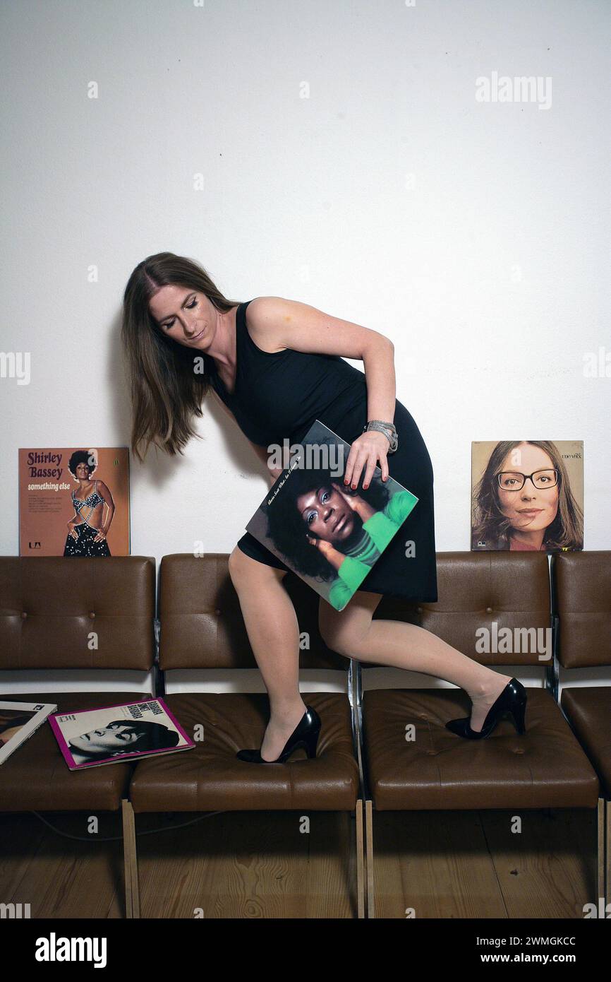 Femme décorant le salon avec la couverture de disque vintage. Banque D'Images