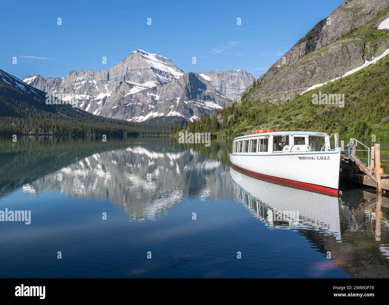 Reflet du bateau Morning Eagle amarré à l'embarcadère du lac Joséphine, Grinell Glacier Trail, Glacier National Park, Montana Banque D'Images