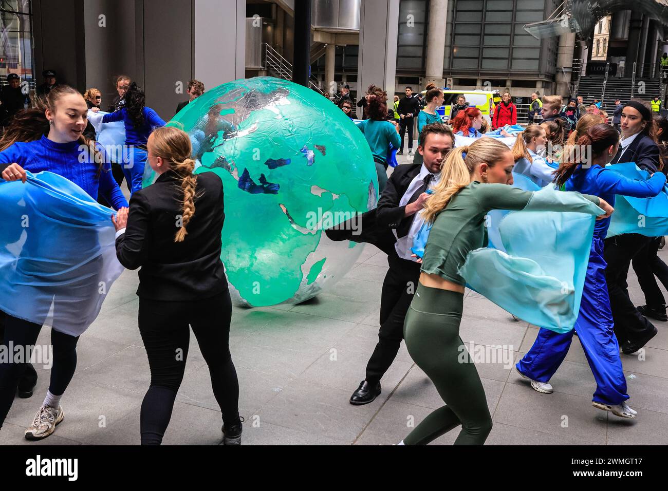 Londres, Royaume-Uni. 26 février 2024. XR (extinction Rebellion) « Mothers Rise Up » danse protester autour d'un globe gonflable géant en face du bâtiment Lloyds of London dans la City de Londres, dans le cadre de la semaine d'action de l'assurance par extinction Rebellion UK. Le groupe vise à persuader Lloyds of London de cesser d'assurer de nouveaux combustibles fossiles. Crédit : Imageplotter/Alamy Live News Banque D'Images