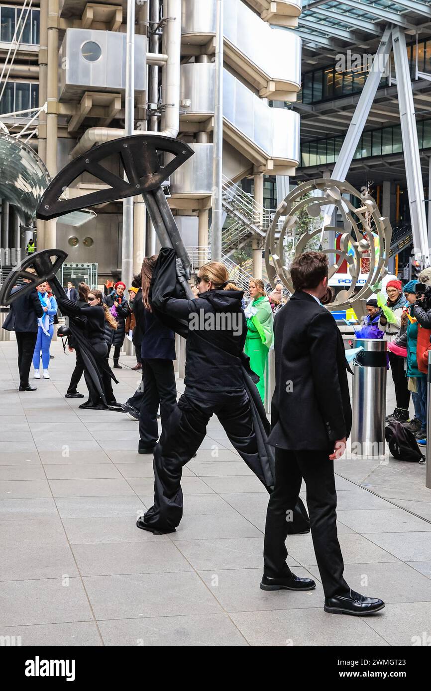 Londres, Royaume-Uni. 26 février 2024. XR (extinction Rebellion) « Mothers Rise Up » danse protester autour d'un globe gonflable géant en face du bâtiment Lloyds of London dans la City de Londres, dans le cadre de la semaine d'action de l'assurance par extinction Rebellion UK. Le groupe vise à persuader Lloyds of London de cesser d'assurer de nouveaux combustibles fossiles. Crédit : Imageplotter/Alamy Live News Banque D'Images