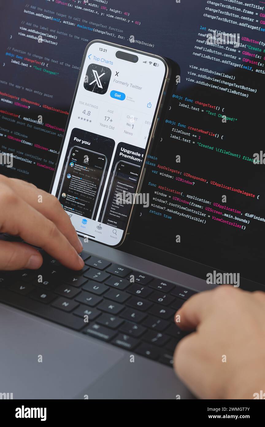 New York, États-Unis - 23 février 2024 : Code pour la nouvelle application X dans l'écran d'ordinateur portable avec les mains sur le clavier Banque D'Images