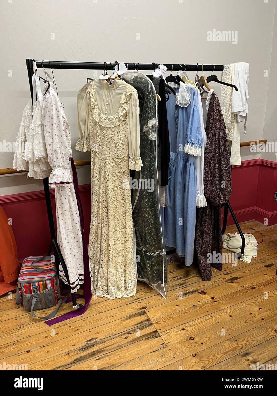 Costumes de théâtre accrochés sur un rail dans les coulisses du théâtre. Robes de style vintage en crème, blanc, bleu et marron. Banque D'Images