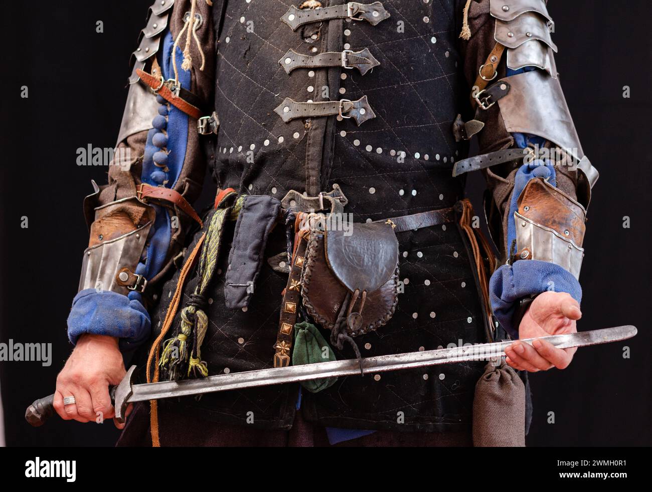 EQUIPEMENT d'un guerrier médiéval avec une épée. Gros plan d'une partie du corps avec une ceinture et des bras. Banque D'Images