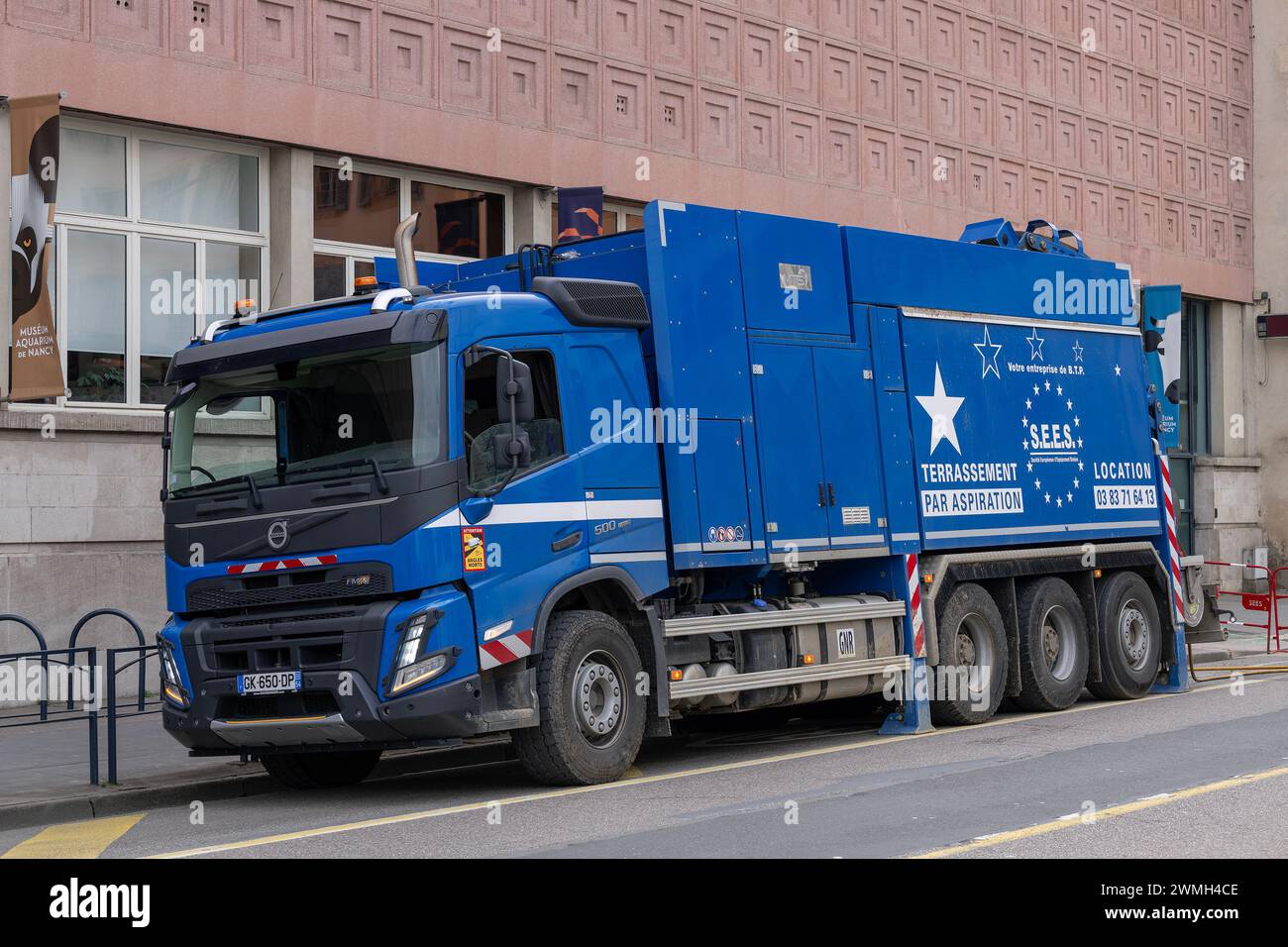 Nancy, France - Focus sur un camion excavateur aspirant bleu Volvo FMX 500 sur un chantier de construction dans une rue. Banque D'Images