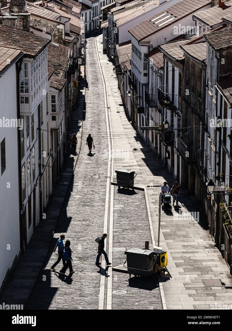 Silhouette d'un petit groupe de personnes marchant le long de Rúa das Hortas à Santiago de Compostelle, Espagne. Banque D'Images