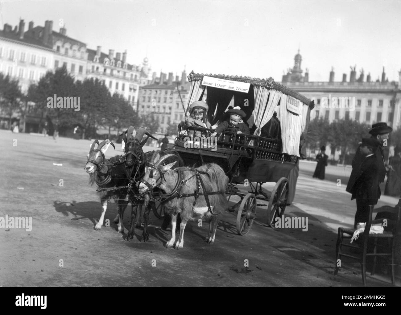 Une calèche tirée par des chevaux avec des enfants traverse un lieu de la ville lyonnaise, au début du XXe siècle. Vieille photo numérisée à partir de plaques de verre. Banque D'Images
