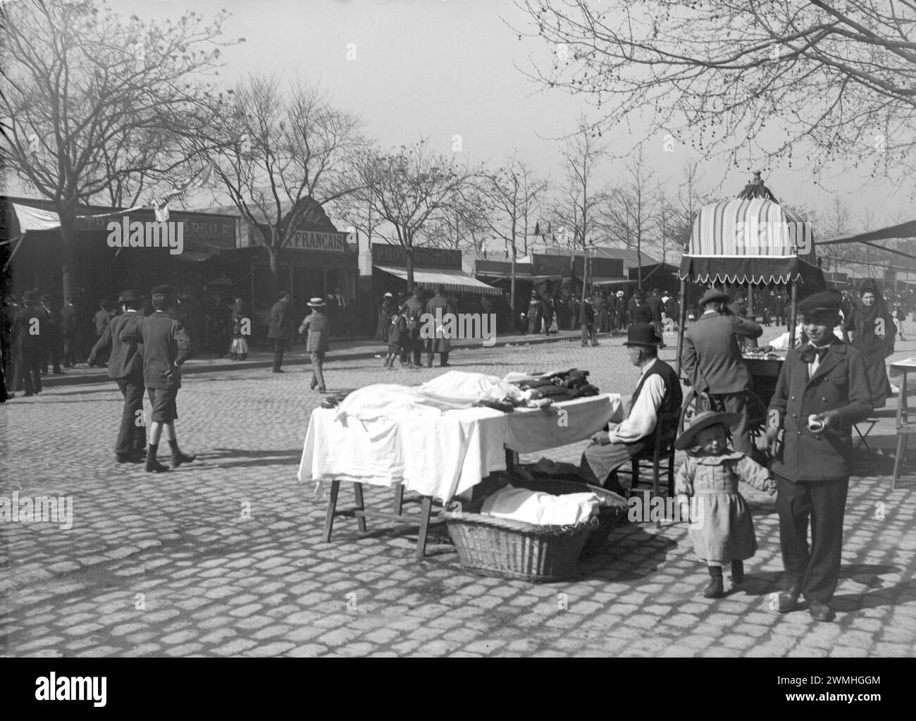 Quelqu'un avec un chapeau melon vendant des meubles dans une rue pavée de Paris. Début du XXe siècle. Ancienne photo restaurée. Banque D'Images