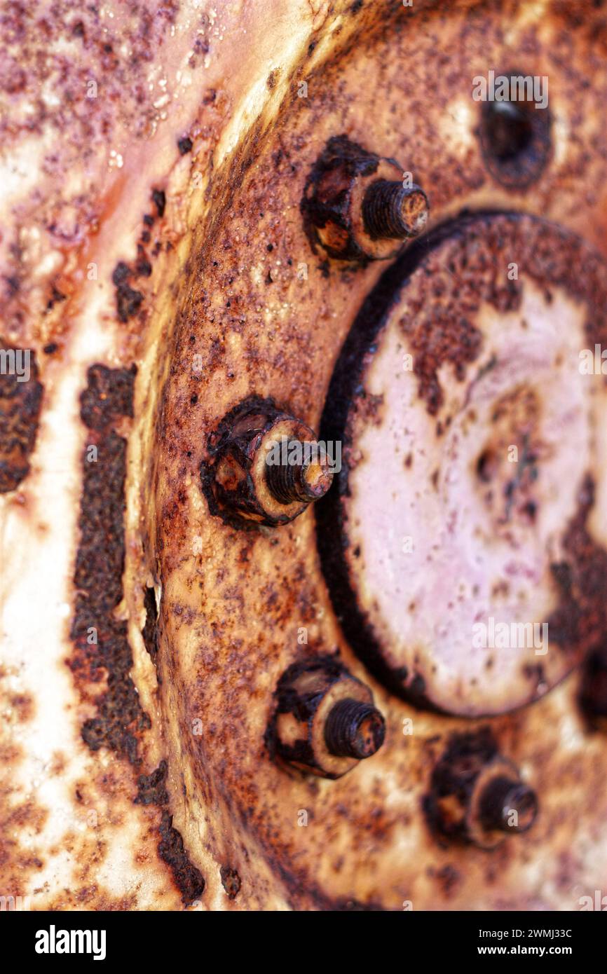 Le moyeu rouillé de la roue du tracteur crée un arrière-plan de texture industrielle. Orientation verticale. Banque D'Images