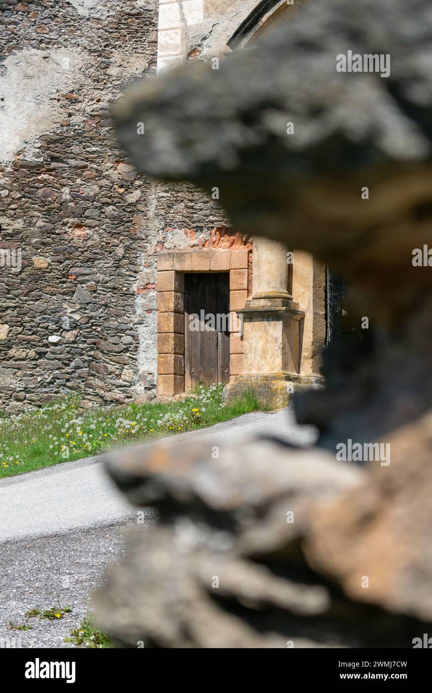 Une vue de l'entrée latérale du château à travers un trou flou dans le mur. Banque D'Images