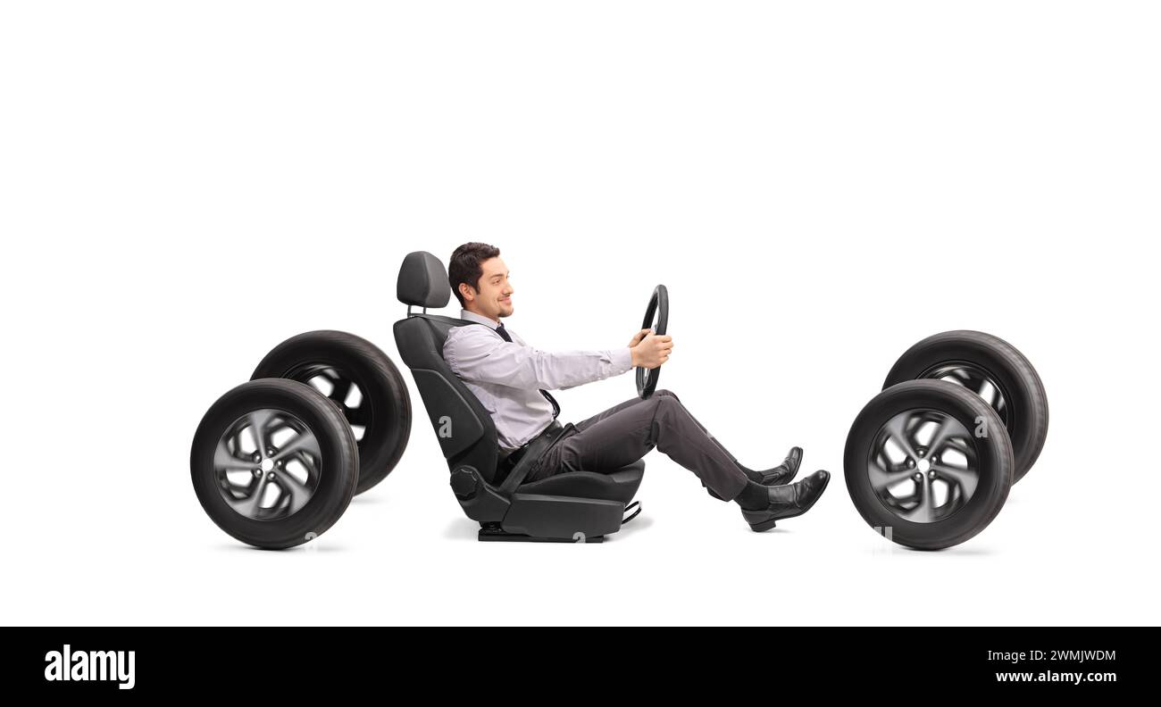 Plan de profil d'un jeune homme tenant un volant assis dans un siège d'auto isolé sur fond blanc Banque D'Images