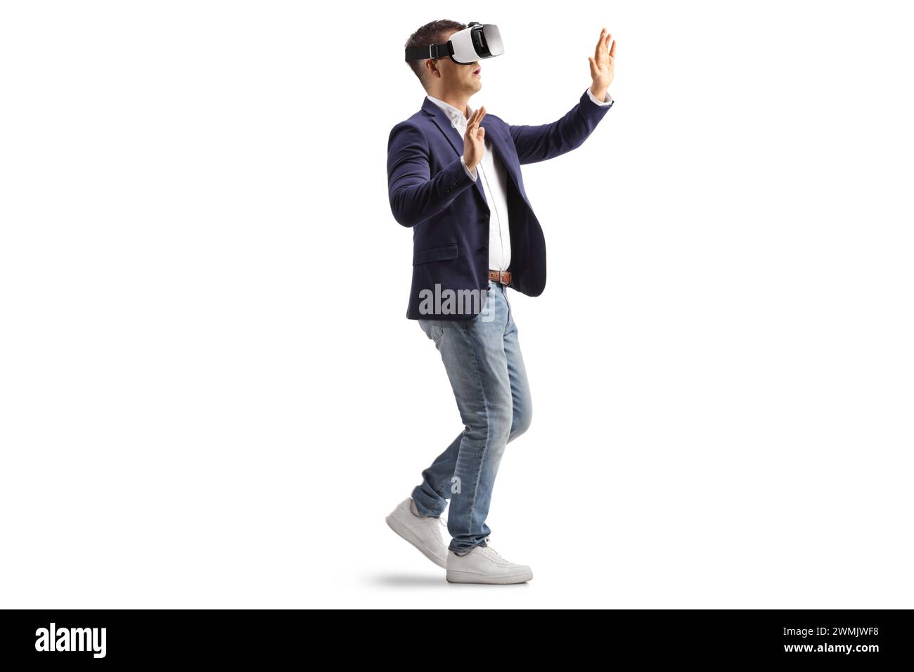 Homme d'affaires avec un casque VR marchant et touchant avec les mains isolées sur fond blanc Banque D'Images