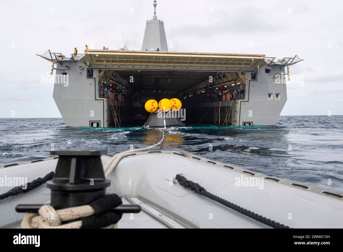 Un bateau gonflable à coque rigide remorque un article d'essai de module d'équipage (CMTA) du pont de puits du navire de transport amphibie de classe San Antonio USS San Diego (LPD 22) pendant le test de récupération en cours 11, le 25 février 2024. En préparation de la mission Artemis II avec équipage de la NASA, qui enverra quatre astronautes à Orion au-delà de la Lune, la NASA et le ministère de la Défense mèneront une série de tests pour démontrer et évaluer les processus, les procédures et le matériel utilisés dans les opérations de récupération pour les missions lunaires avec équipage. Les quais de transport amphibies, comme l'USS San Diego, ont des capacités uniques qui en font un i. Banque D'Images