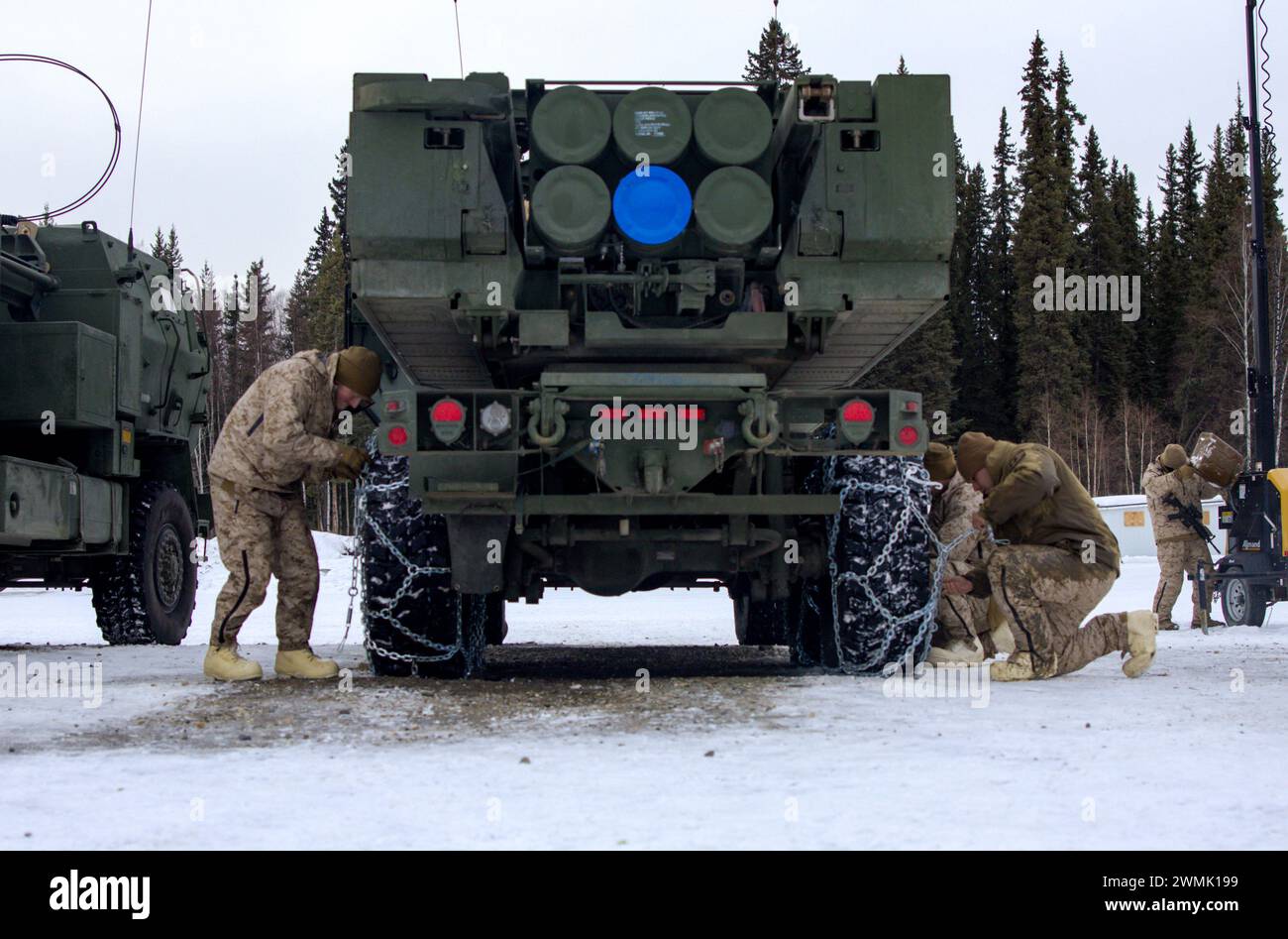 U.S. Marines avec Fox Battery, 2nd Battalion, 14th Marine Regiment, 4th Marine Division, Marine Forces Reserve, attachez des chaînes à neige aux pneus d’un véhicule HIMARS (High Mobility Artillery Rocket System) pendant l’exercice Arctic Edge 2024 à la base aérienne d’Eielson, en Alaska, le 22 février 2024. Le système d'armes HIMARS est un élément crucial de l'élément de combat au sol de la Marine Air-Ground Task Force (MAGTF). Les HIMARS jouent un rôle central dans la fourniture de feux de précision à longue portée pour soutenir les objectifs du MAGTF, des opérations expéditionnaires aux combats soutenus sur tous les terrains et tous les climats. Edg. Arctique Banque D'Images