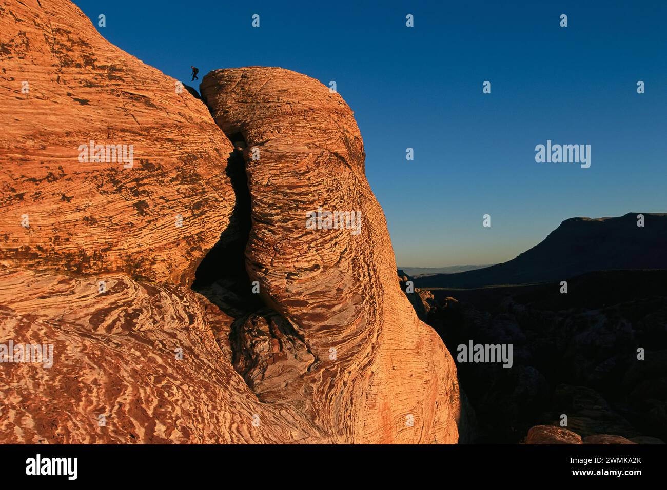 Grimpeur saute de rocher en rocher sur des dunes pétrifiées au Red Rock Canyon du Nevada près de Las Vegas, l'un des plus visités du Bureau of Land Management... Banque D'Images