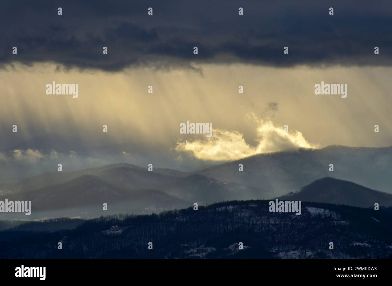 La lumière du soleil coule à travers les nuages orageux au-dessus des Blue Ridge Mountains au crépuscule ; Caroline du Nord, États-Unis d'Amérique Banque D'Images