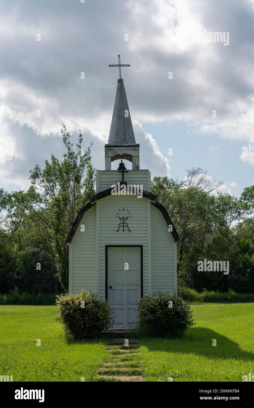 Église miniature dans la Saskatchewan rurale, entourée d'une belle cour verte ; Forget, Saskatchewan, Canada Banque D'Images