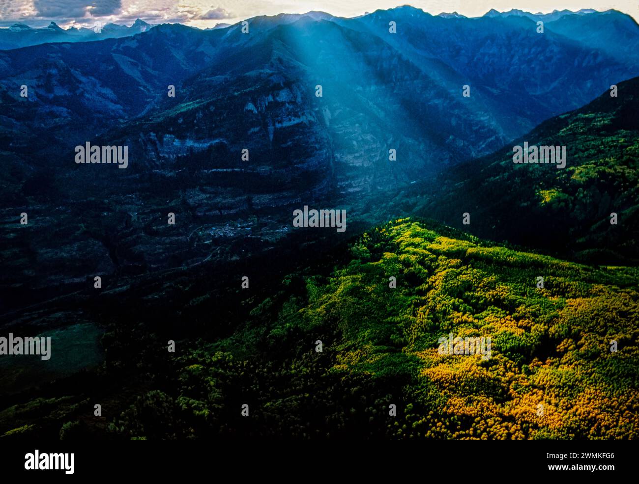La lumière du soleil sépare les nuages et illumine un peuplement de trembles dans les montagnes sauvages et accidentées de San Juan. Arbres en argent, pas la lumière du soleil, attirés ... Banque D'Images