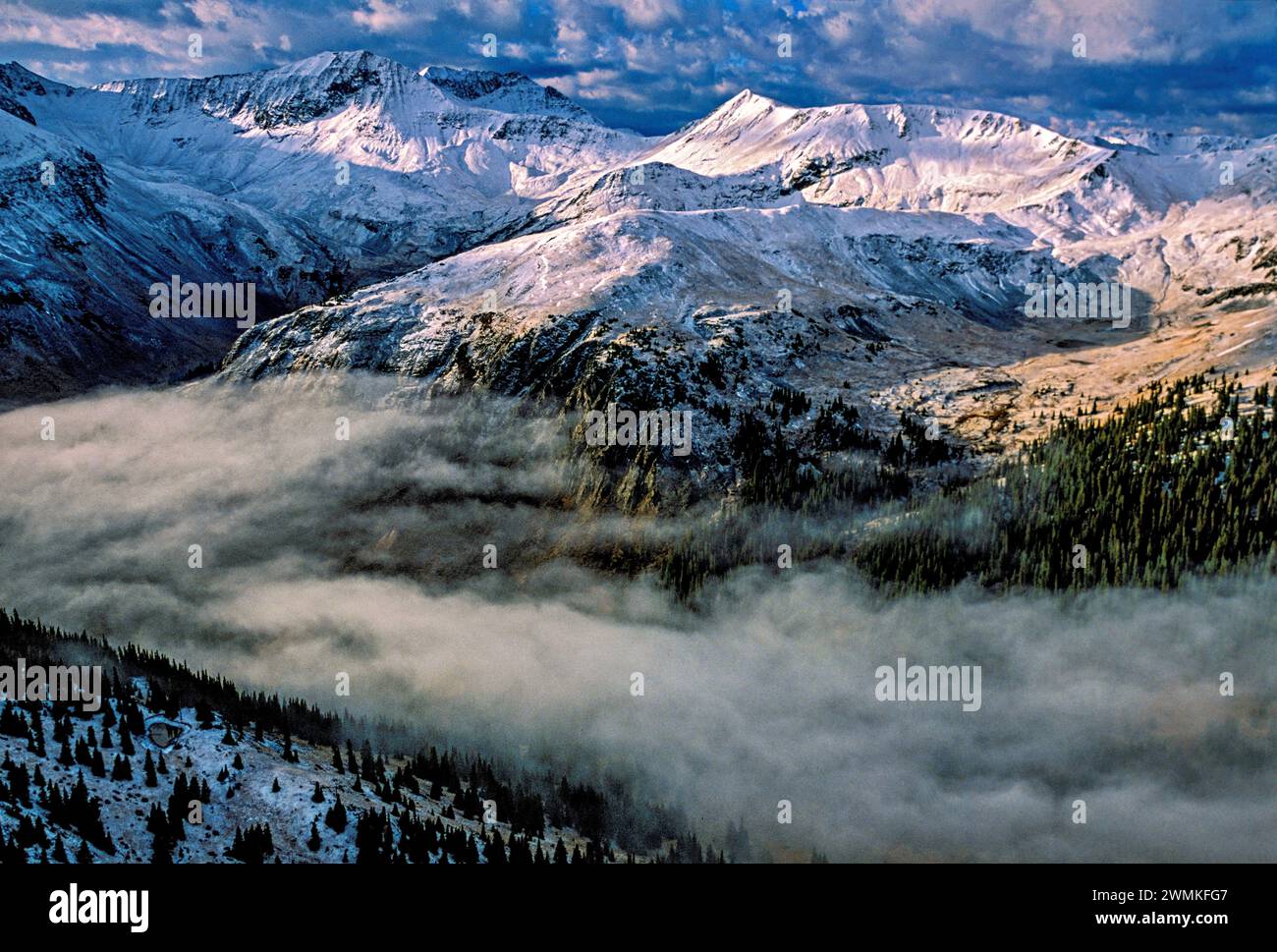 Le brouillard matinal remplit la vallée entre les sommets enneigés et blancs des montagnes sauvages de San Juan. Des puits d'argent, pas la lumière du soleil, attirent les mineurs dans... Banque D'Images