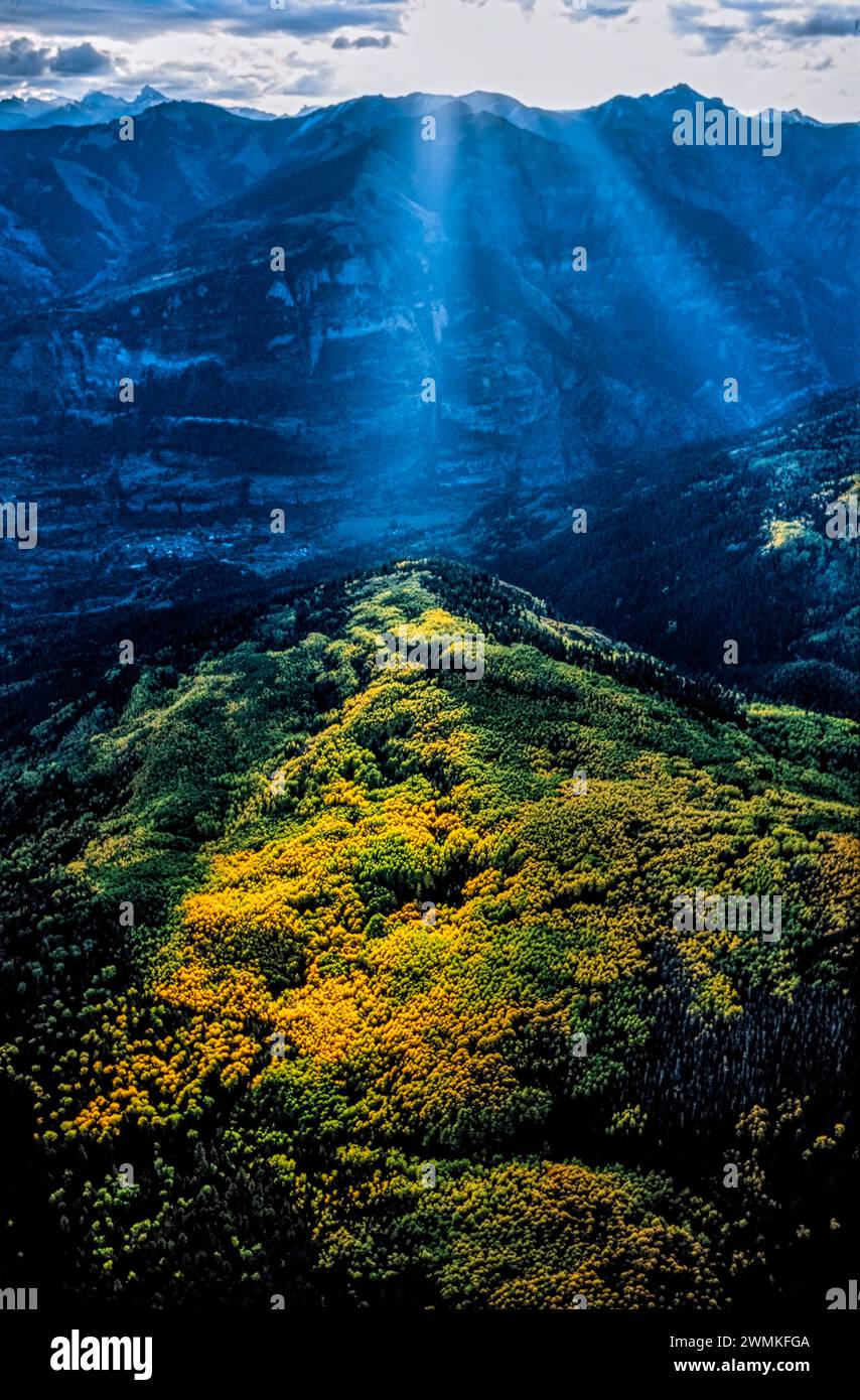 La lumière du soleil sépare les nuages et illumine un peuplement de trembles dans les montagnes sauvages et accidentées de San Juan. Arbres en argent, pas la lumière du soleil, attirés ... Banque D'Images