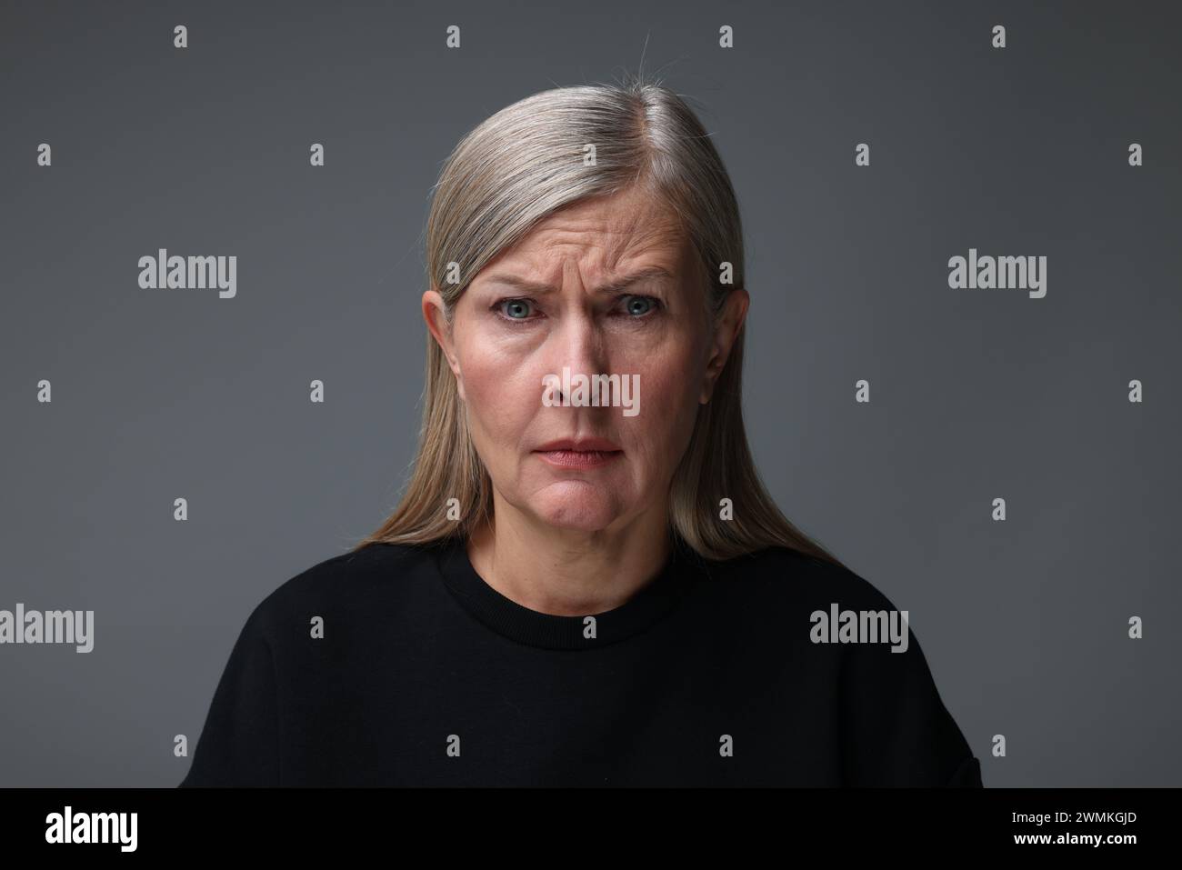 Concept de personnalité. Portrait de femme émotionnelle sur fond gris Banque D'Images