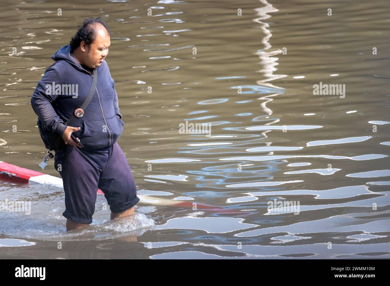 SAMUT PRAKAN, THAÏLANDE, février 02 2024, Un homme patente prudemment dans une rue inondée Banque D'Images