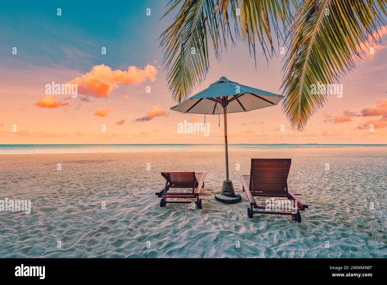 Plage tranquille de sable de mer coucher de soleil ciel de détente. Couple d'amour concept de paysage de voyage de liberté romantique. Chaises exotiques idylliques parasol, feuilles de palmier Banque D'Images