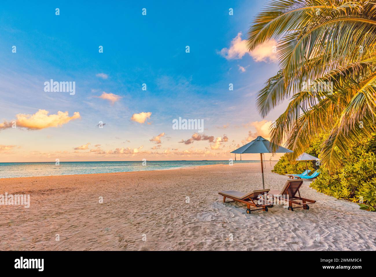 Plage tranquille de sable de mer coucher de soleil ciel de détente. Couple d'amour concept de paysage de voyage de liberté romantique. Chaises exotiques idylliques parasol, feuilles de palmier Banque D'Images